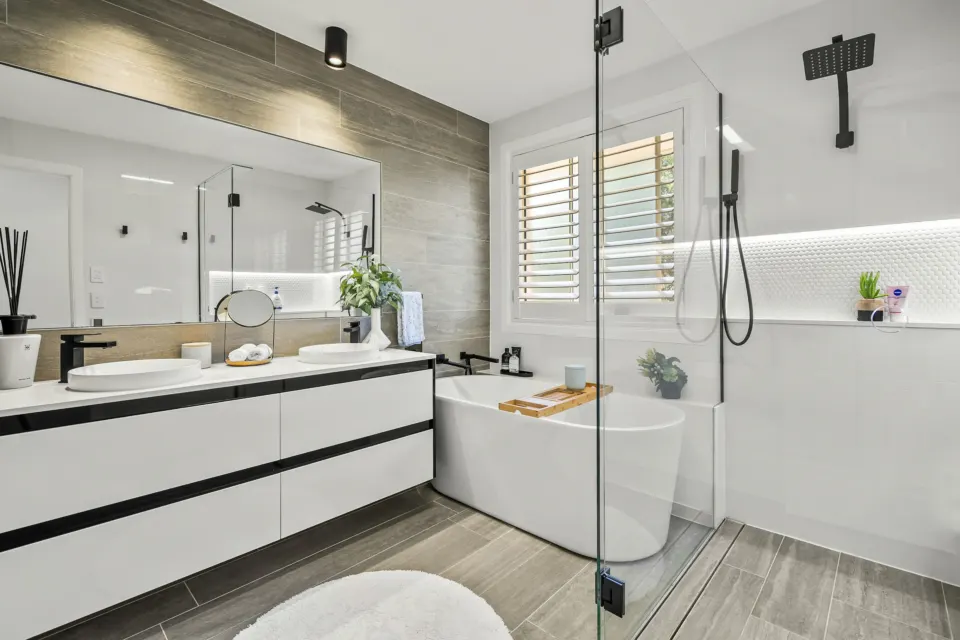 White bathroom with a floating vanity, freestanding tub and glass shower