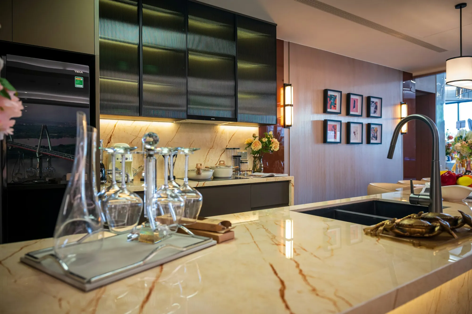 Kitchen with dark upper cabinets, glass-front doors and veined marble countertops