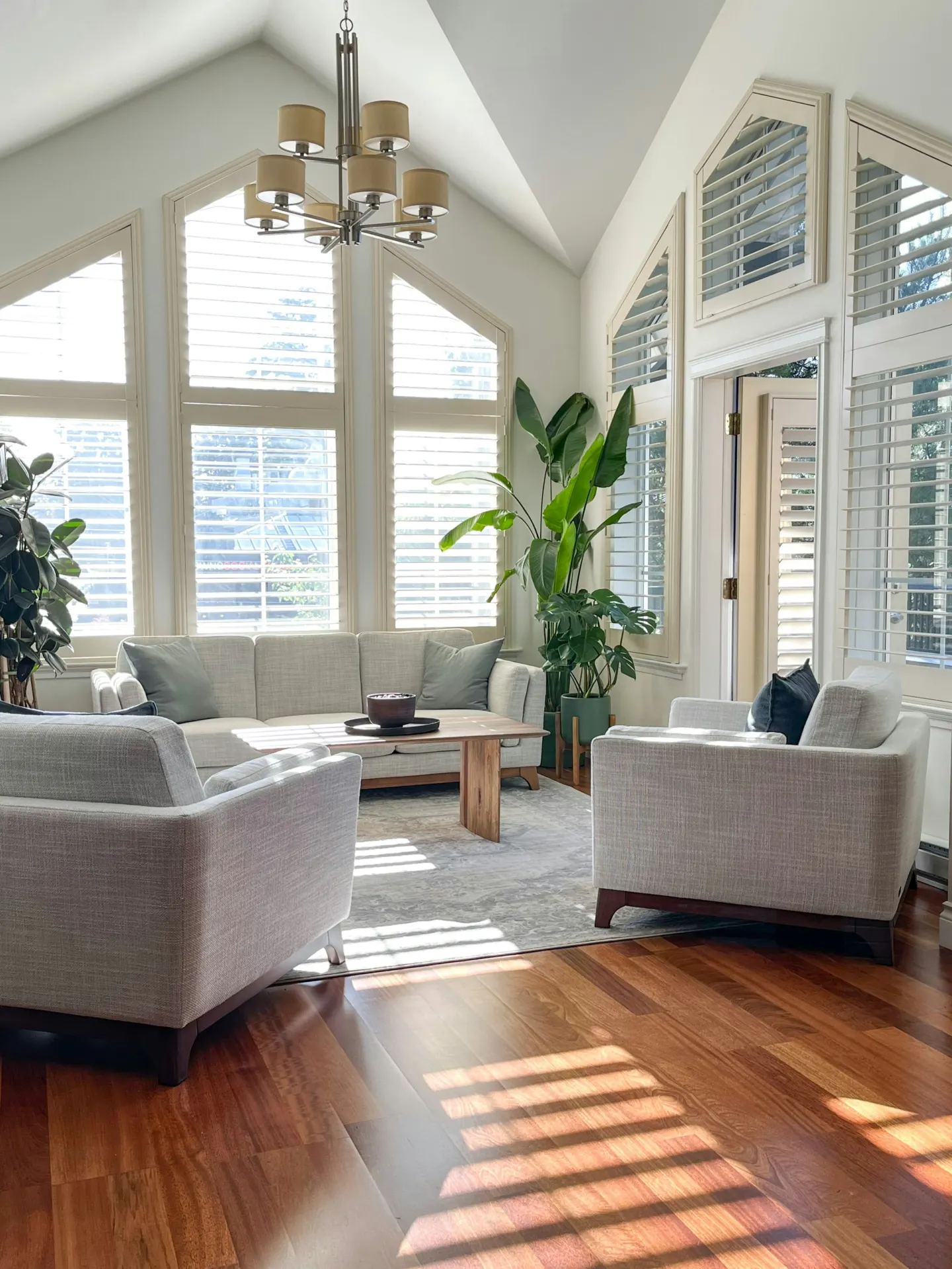 Bright living room with a vaulted ceiling and tall windows